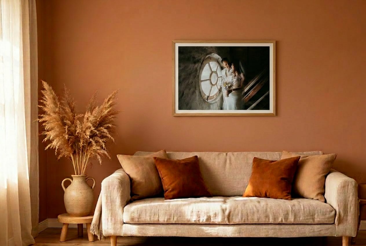 Wanddecoratie met trouwfoto boven een bank in een warme woonkamer