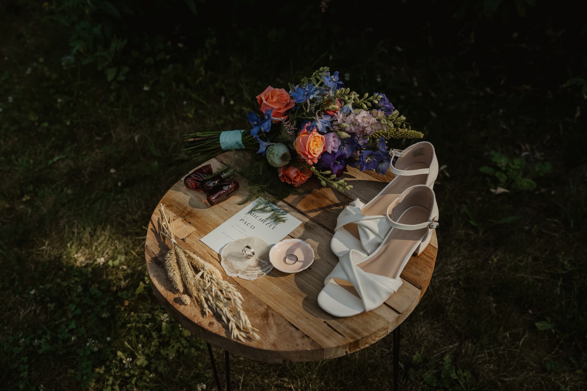 Trouwdetails met boeket, ringen en bruidsschoenen op een houten tafel