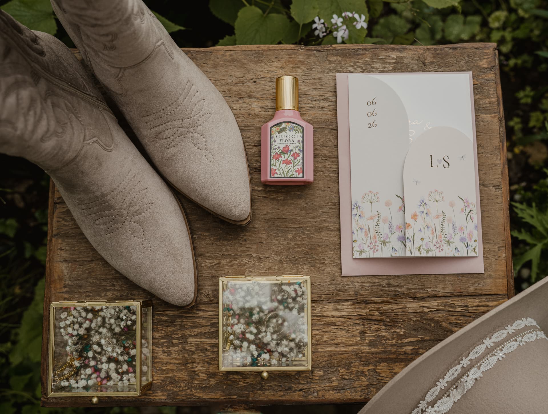 Trouwdetails met laarzen, parfum en trouwkaart op hout